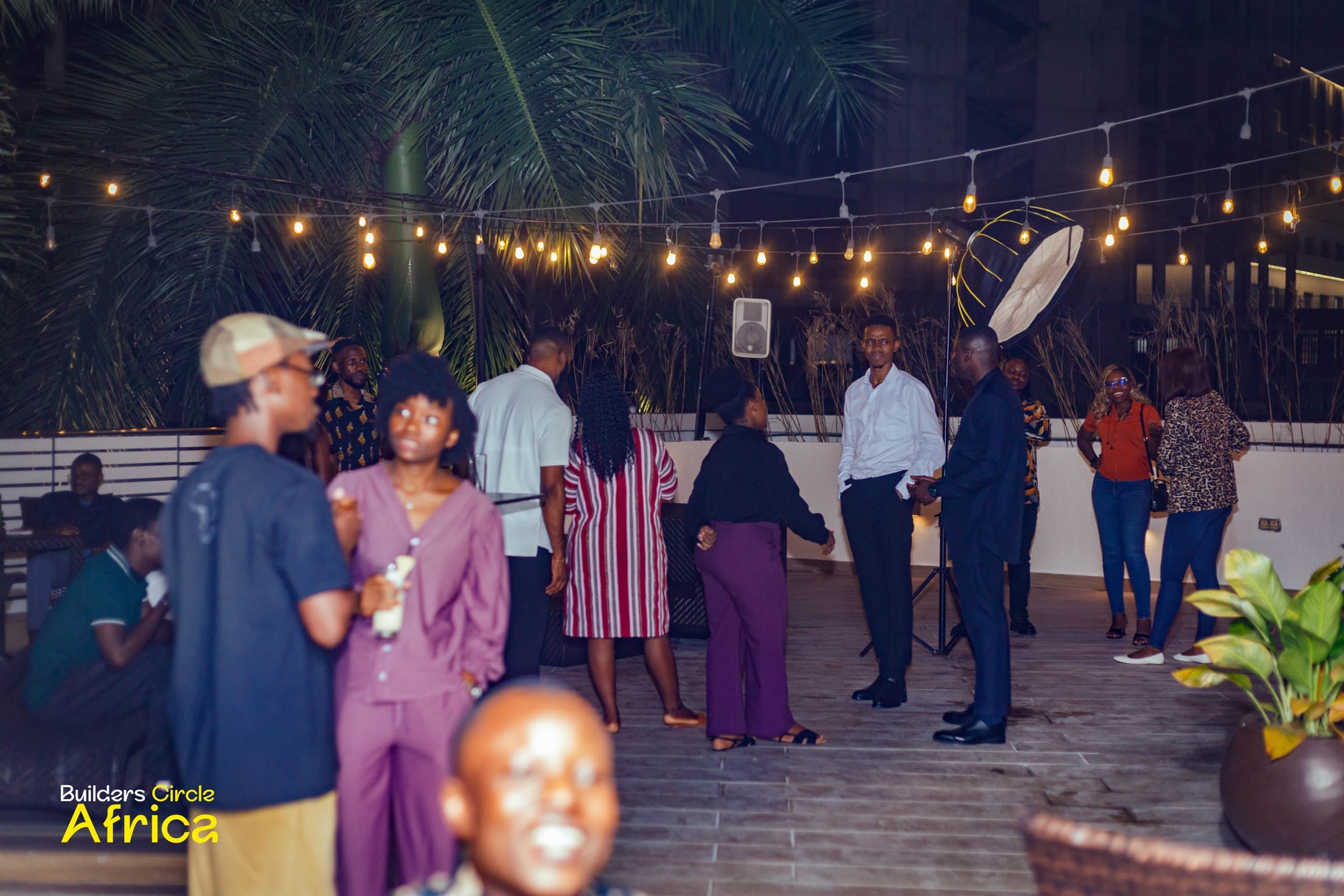 The poolside crowd under string lights